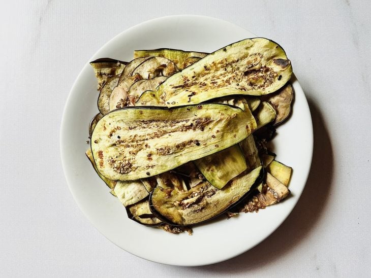 Fatias de berinjela fritas e acomodadas em um prato.