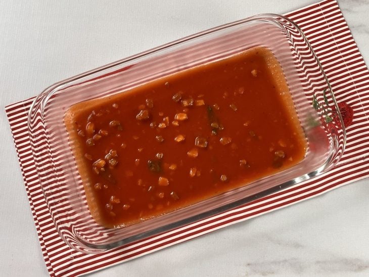 Um refratário forrado com molho de tomate.