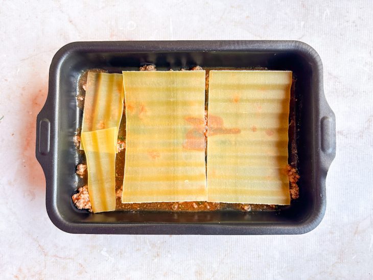 Na forma, a carne moída e as lâminas de massa.