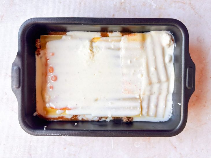 Presunto e molho branco adicionados.