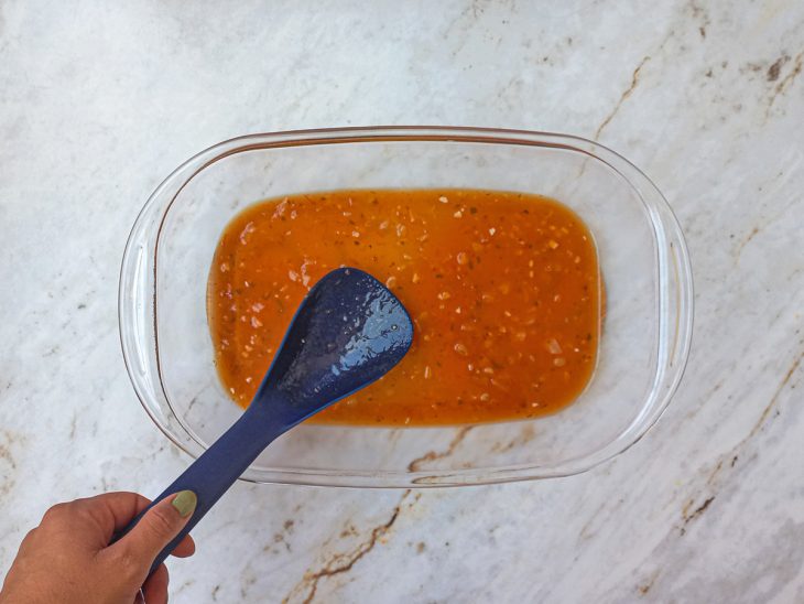 Molho de tomate transferidos para uma travessa de vidro.