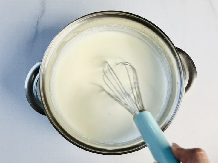 Leite integral, creme de leite, sal, pimenta-do-reino e noz-moscada adicionados a panela.