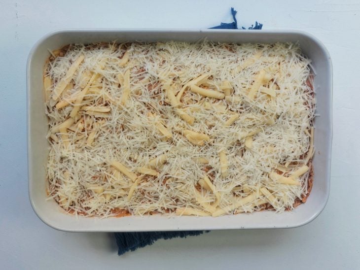 Um refratário contendo lasanha de frango com queijo.