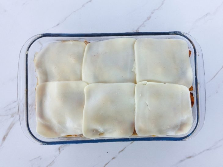 Lasanha coberta com queijo mussarela.