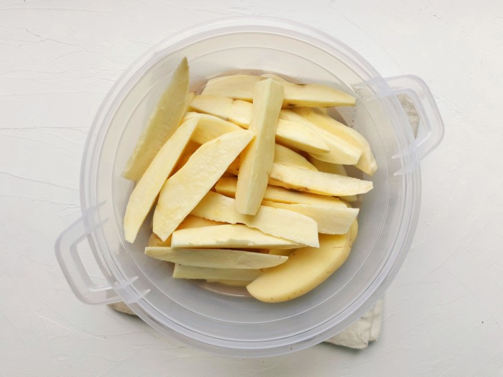 Um recipiente com os palitos de batatas e água.
