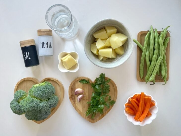 Ingredientes organizados na bancada com legumes higienizados, alho e manteiga separados.