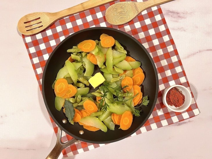 Legumes na panela com pedaço de manteiga e temperos.