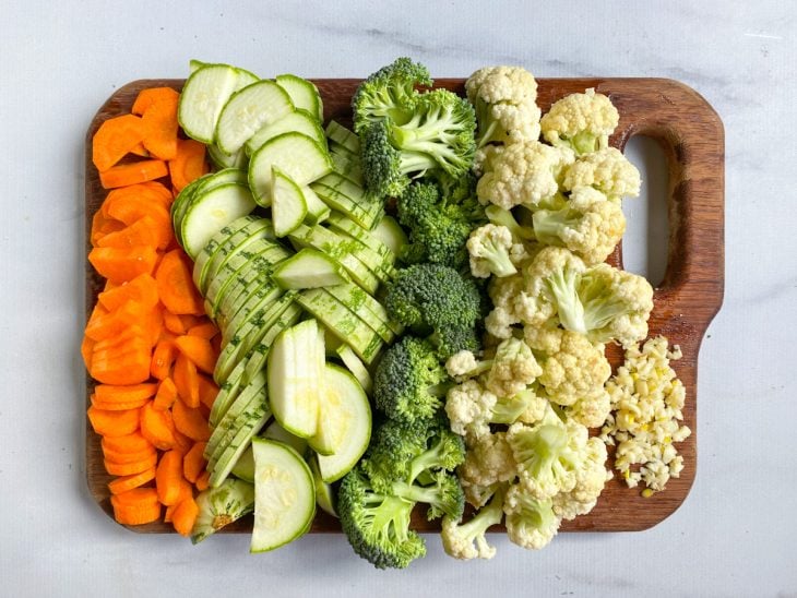 Uma tábua com os vegetais cortados.