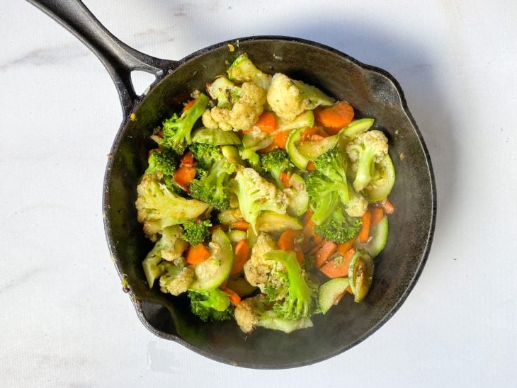 Uma frigideira com os vegetais e temperos.