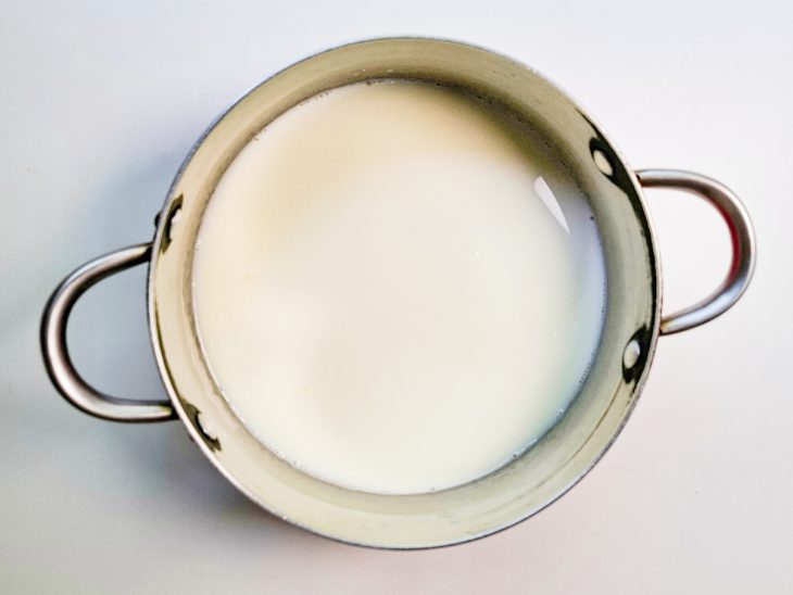 Açúcar e leite colocados numa panela.