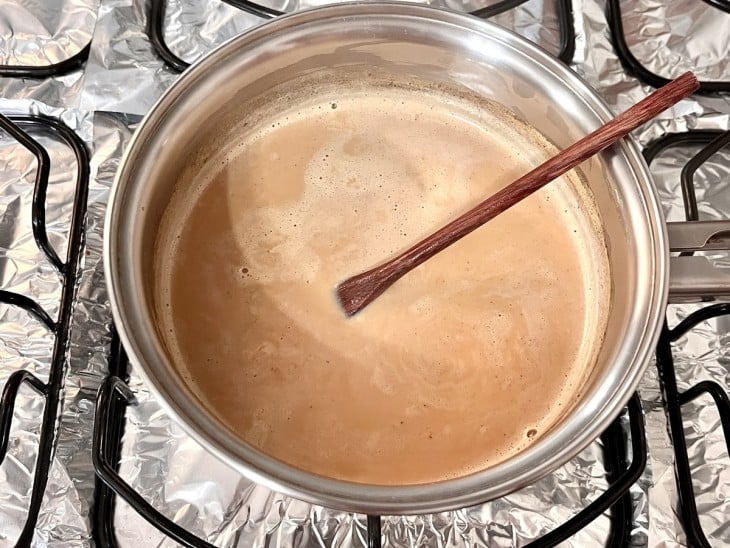 Uma panela com a mistura de leite, canela e caramelo.