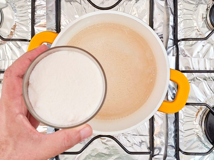 Açúcar sendo dissolvido na água quente para formar a calda.