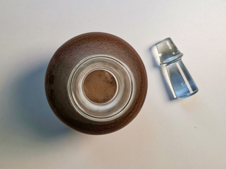 Licor sendo transferido para uma garrafa de vidro com funil.