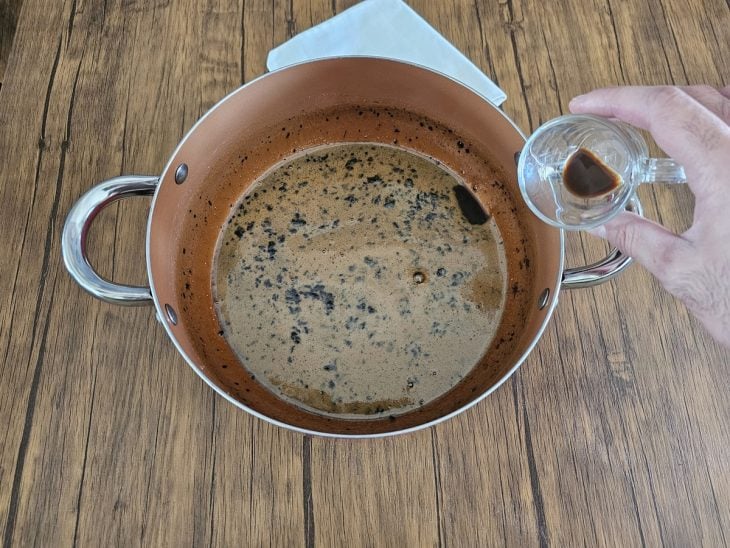 Uma panela com água, açúcar, café e extrato de baunilha.