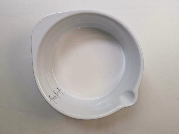 Líquido de coco sendo coado em peneira fina.