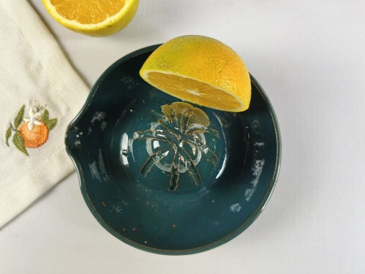 Uma metade de laranja sobre um espremedor.