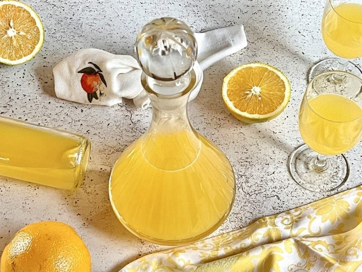 Uma jarra e taças contendo licor de laranja.