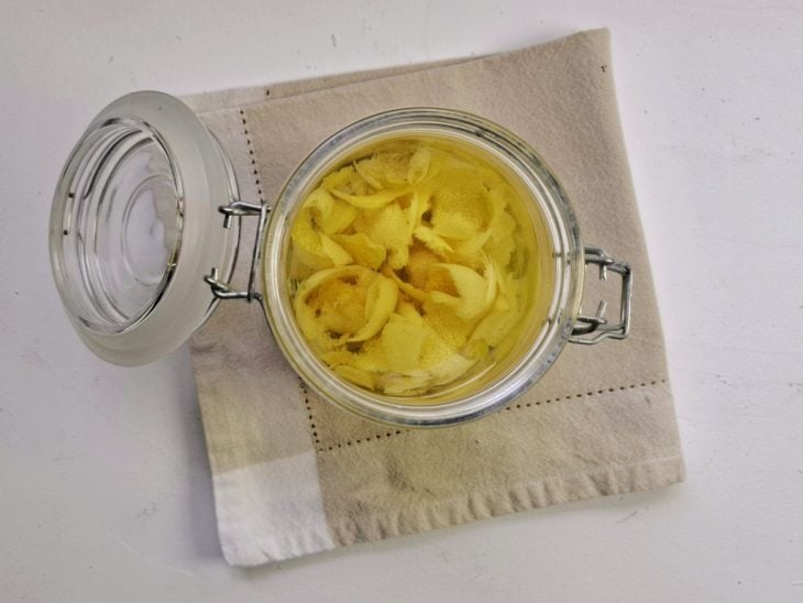 Pote hermético com cascas de limão e vodca.