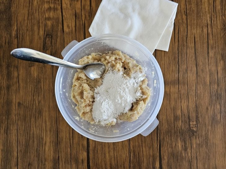 Um recipiente com frango temperado e farinha de arroz.