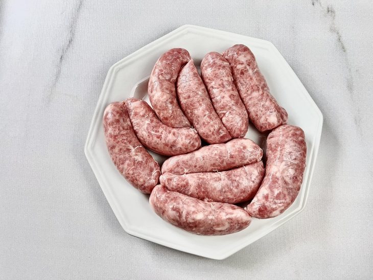 Gomos de linguiça em um prato branco.