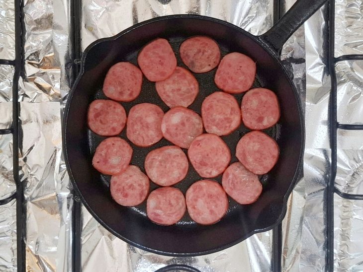 Rodelas de calabresa acomodadas na frigideira.