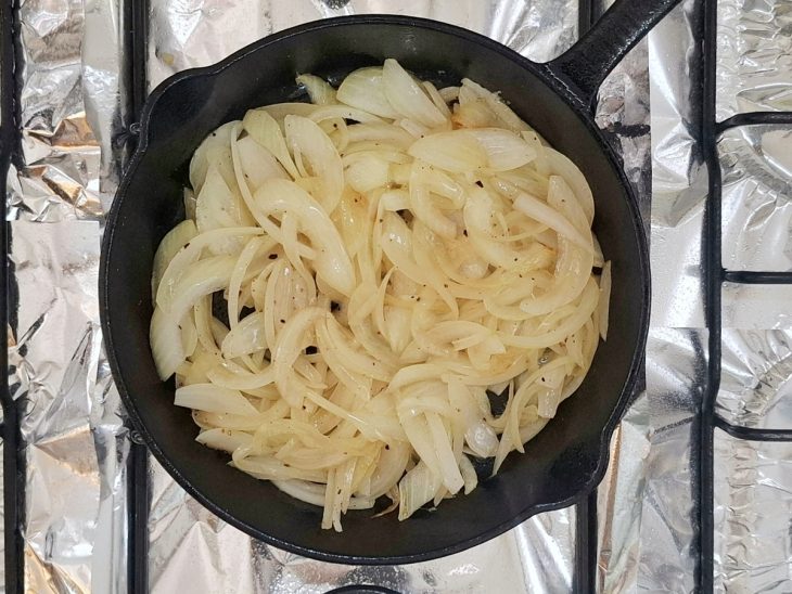 Cebola com temperos adicionados na frigideira.