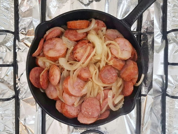 Calabresa, linguiça toscana e pimenta-de-cheiro adicionados na frigideira com cebola.