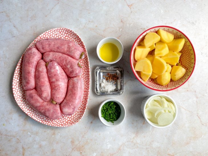 Ingredientes necessários para a receita de linguiça toscana na panela de pressão reunidos em uma bancada.