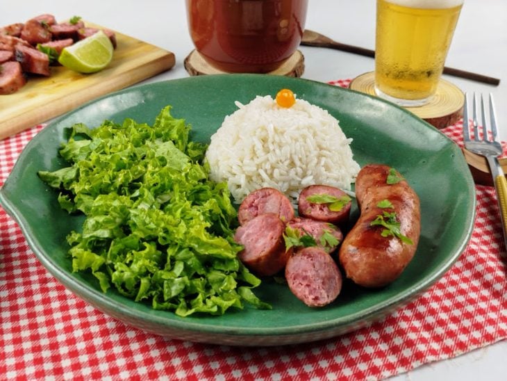 Linguiça toscana servida com arroz e salada.