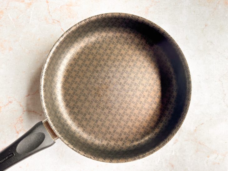 Panela larga vazia aquecendo em fogo bem baixo.