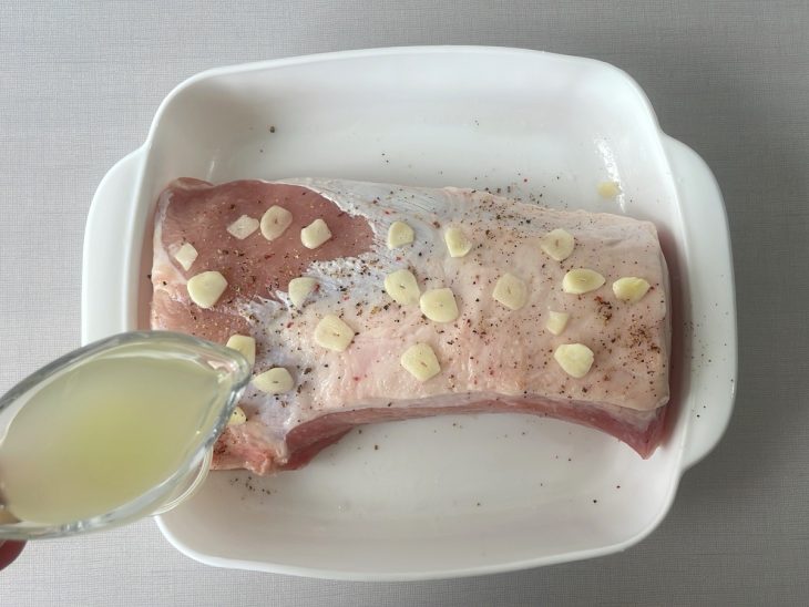 Lombo sendo temperado com alho, pimenta e o suco de limão.