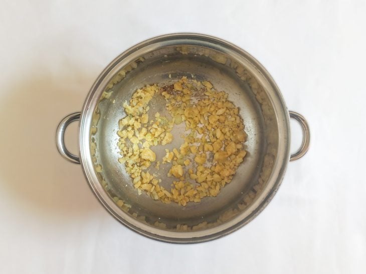 Cebola refogada na margarina e farinha de trigo adicionada na panela.