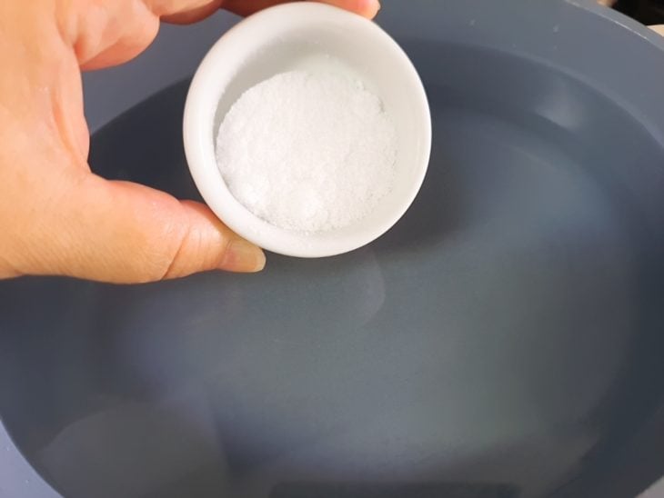 Uma panela com água e a adição de sal.