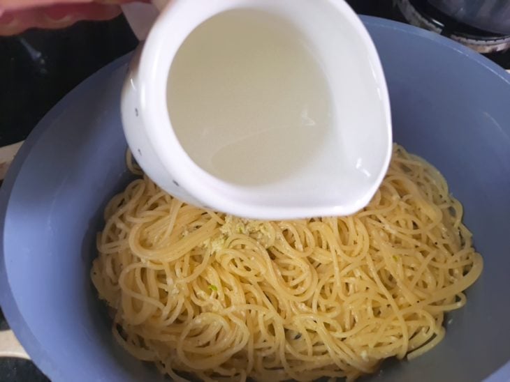 Uma tigela com o molho sendo misturado ao macarrão.