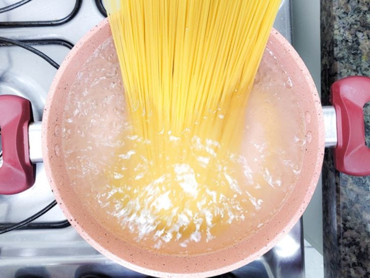 Uma panela contendo água com sal e macarrão espaguete.