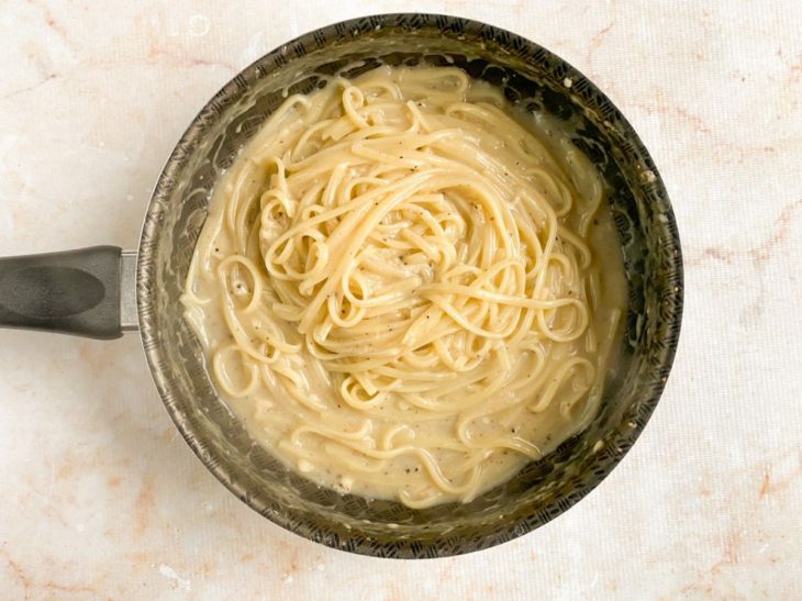 Queijos adicionados a frigideira com o macarrão.