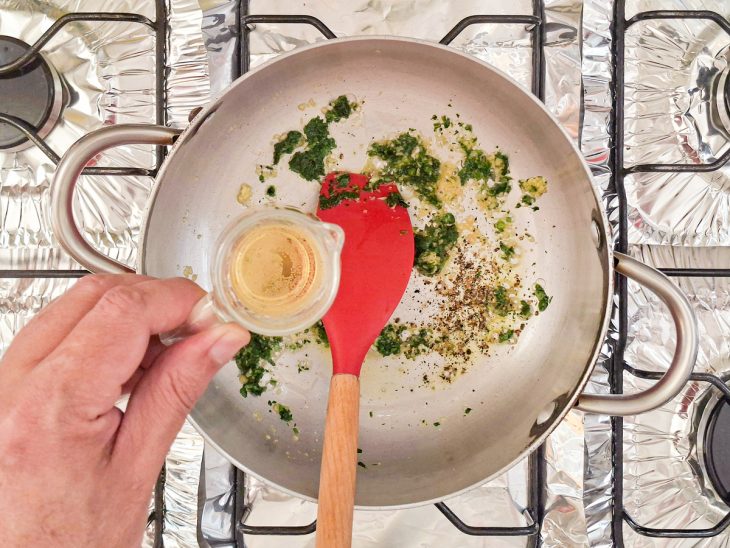 Vinho branco sendo adicionado ao molho.