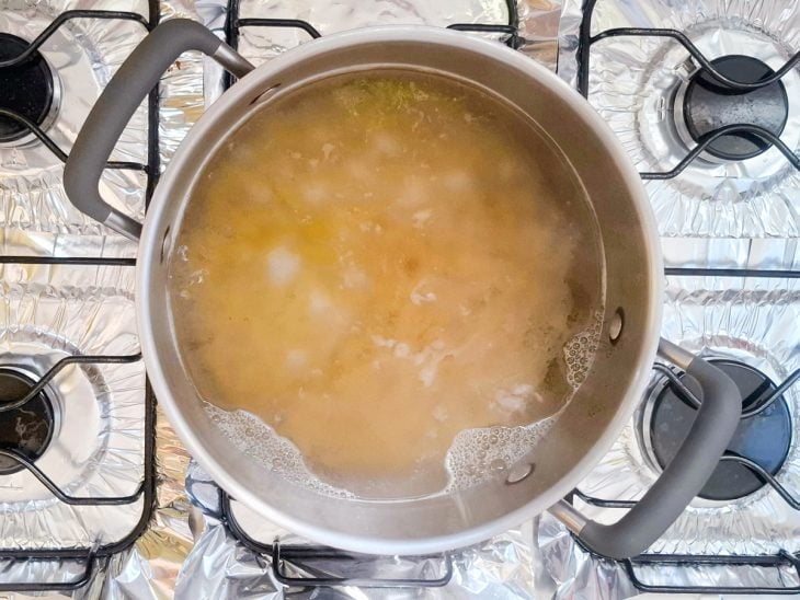 Macarrão em processo de cozimento numa panela com água fervente.