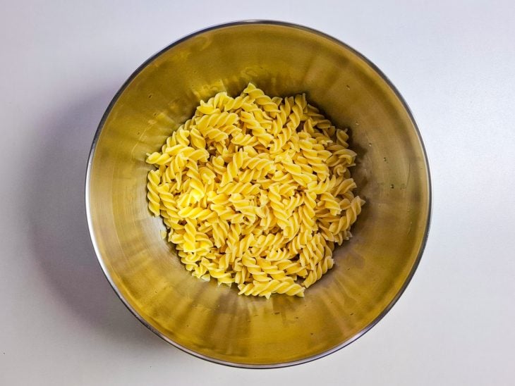 Macarrão cozido reservado num recipiente redondo de inox.