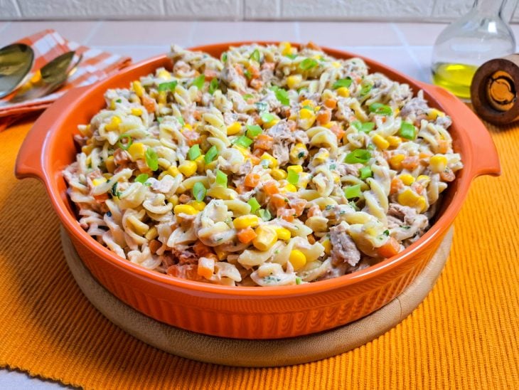 Macarrão com atum e maionese servido em um refratário redondo.