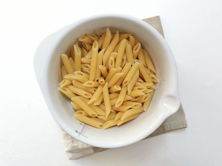 Um recipiente contendo macarrão pene cozido al dente.