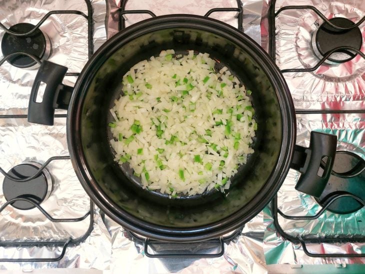 Uma panela refogando cebola e alho.