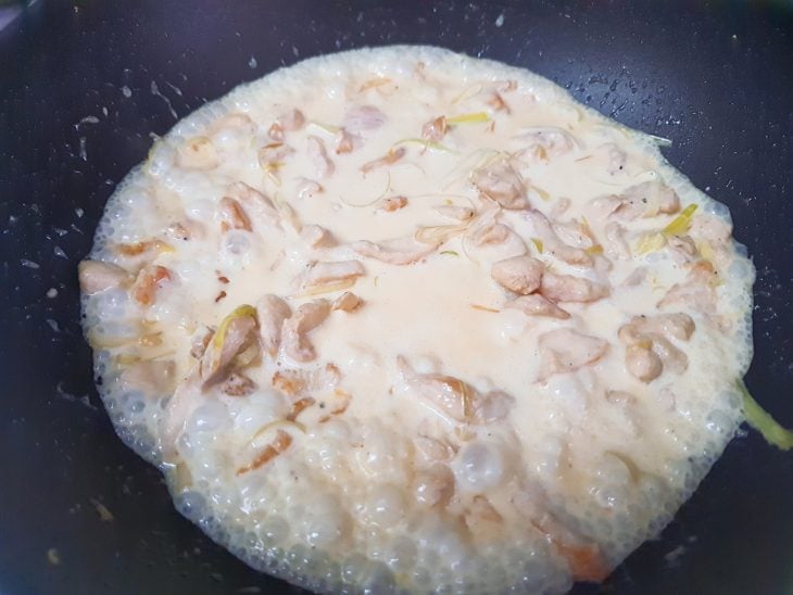 Uma frigideira com a mistura dos ingredientes do frango e molho.
