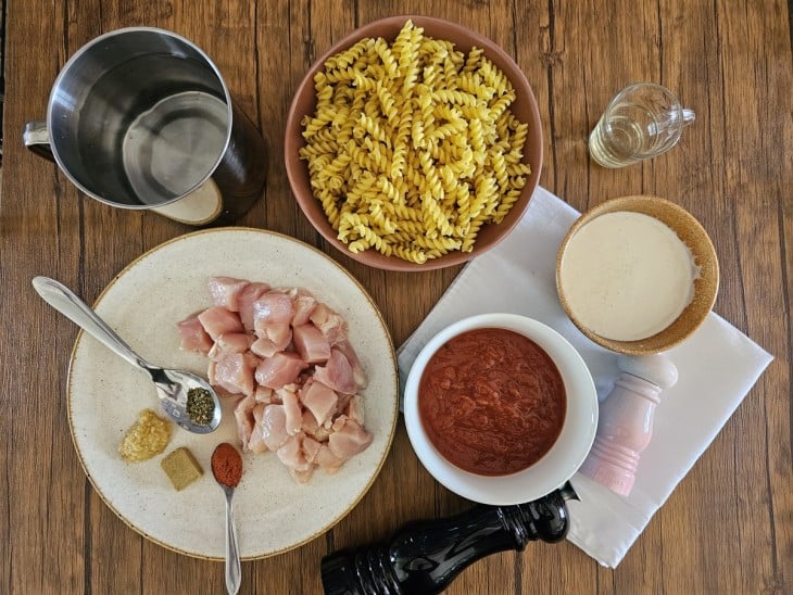 Todos os ingredientes do macarrão com frango na panela de pressão reunidos.