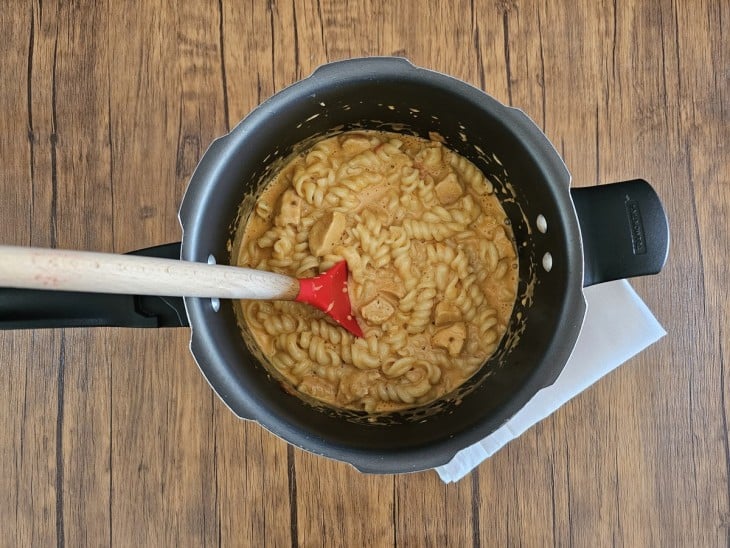 Creme de leite e macarrão cozido misturado na panela de pressão.