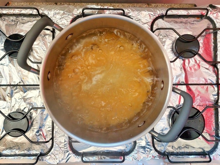 Uma panela com água fervente cozinhando macarrão.