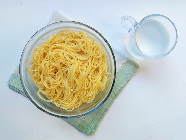 Um recipiente com macarrão cozido.