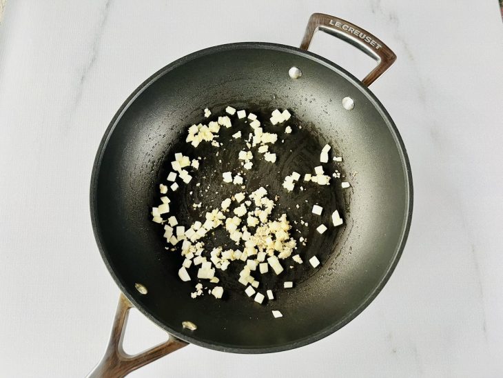 Cebola sendo refogada no óleo da sardinha até dourar.