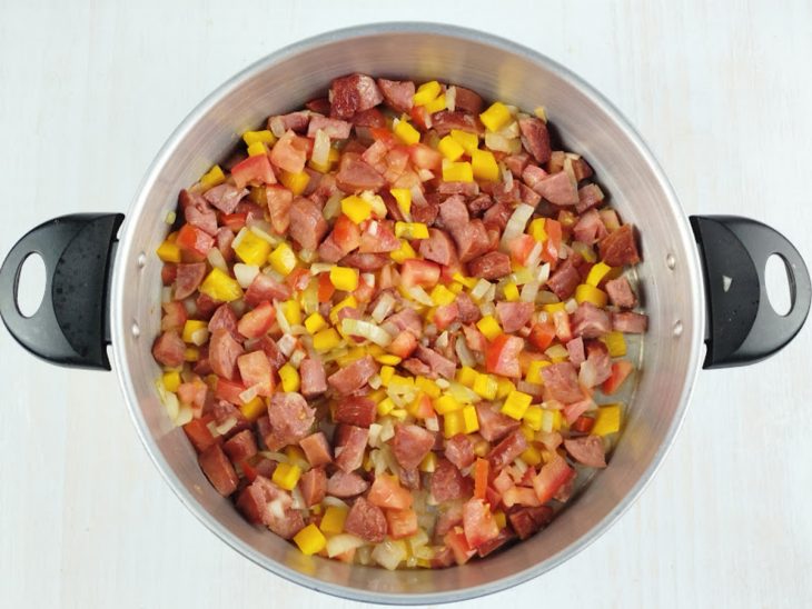 Alho, cebola, tomate e pimentão sendo refogados.