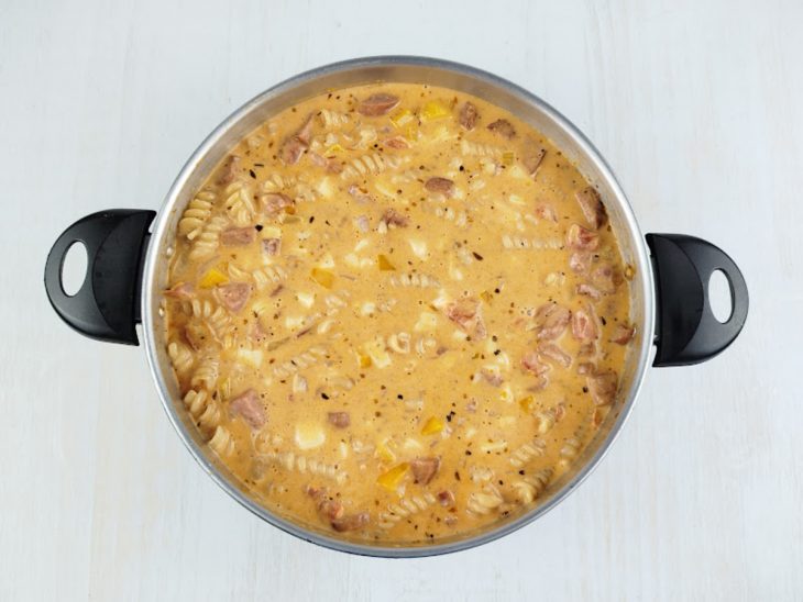 Requeijão, creme de leite e mussarela sendo misturados na massa.